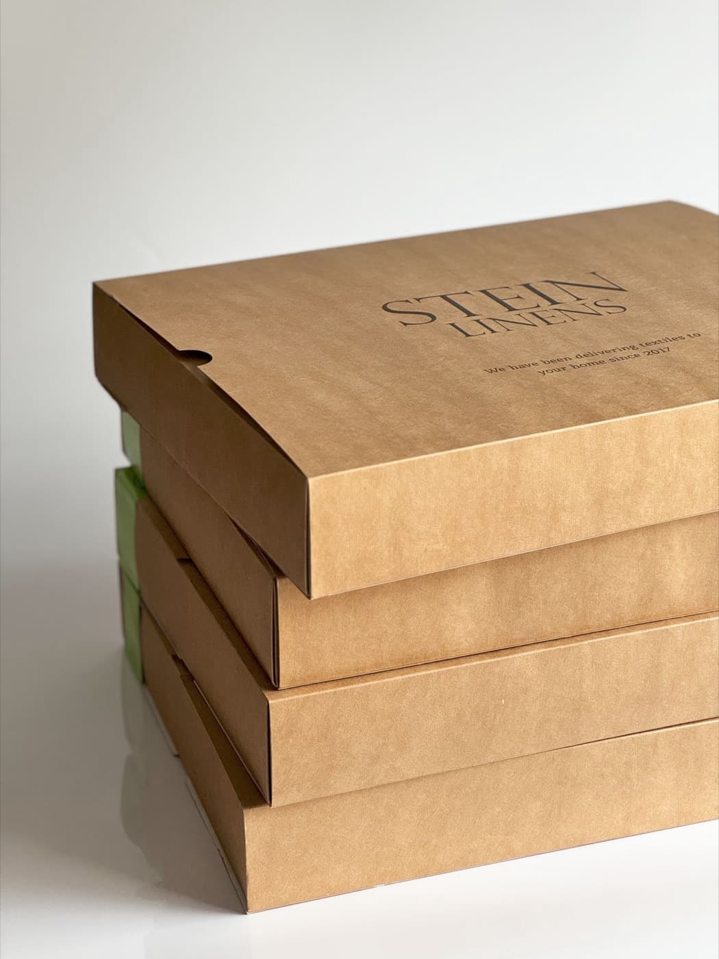 Stacked rigid boxes with a blind-debossed brand mark